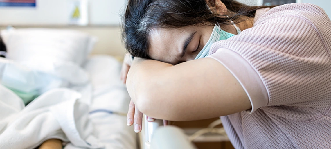 Person resting head on arms appearing tired and fatigued