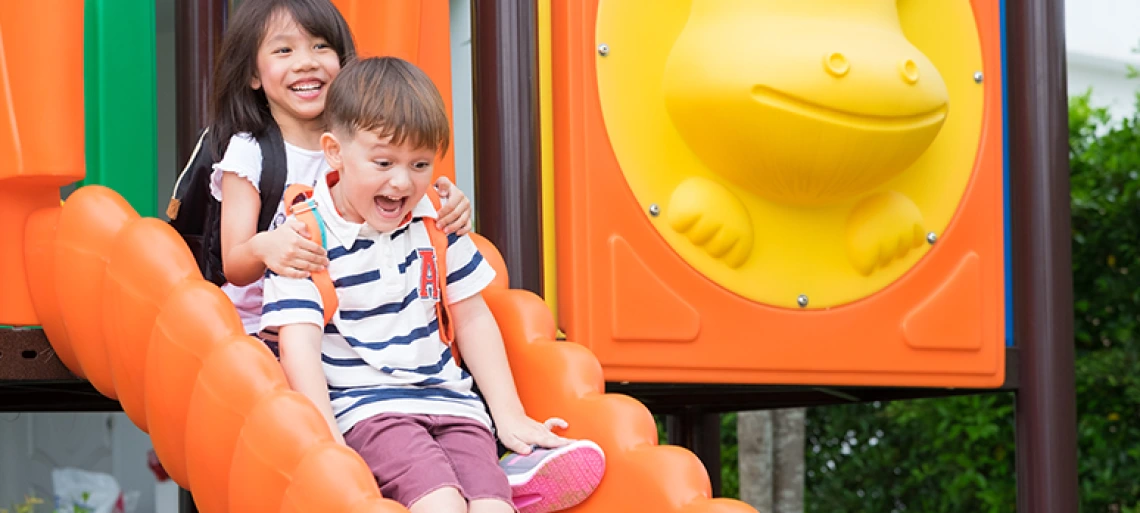 two kids going down a slide